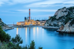 Mediterranean coast with power plant and its coal pier in the town.