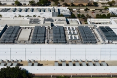 Server farm data center building aerial view roof with cooling units generating computing power.