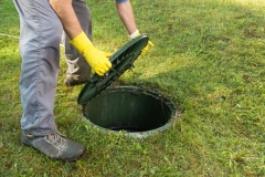 Opening septic tank lid. Cleaning and unblocking septic system and draining pipes.........