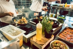 Various fresh ingredients on the stove of a commercial kitchen