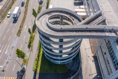 Aerial view of rooftop parking ramp. Spiral ramp leading cars to parking lot on the top of a building.