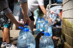 Collecting natural spring water with day zero water crisis with plastic water bottle at Newlands natural spring Cape Town South Africa with water shortage disaster.