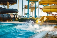 An woman descended from a slide into a pool with transparent water