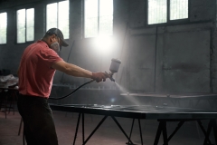 Male worker using spraying machine for painting metal