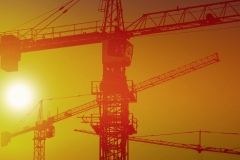 Silhouette of the modern construction site with cranes during a summer sunset