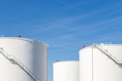 white tanks in tank farm with iron staircase