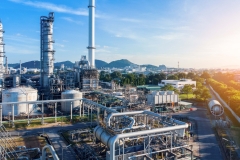 Aerial view of chemical oil refinery plant, power plant on blue sky background.
