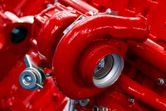 Turbocharger of red powerful engine, turbine of diesel motor for oversize trucks, SUV, cargo, commercial and construction vehicles, heavy industry, detail