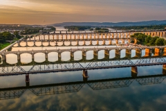 Many bridges over river in sunset, Harrisburg, Pennsylvania, Susquehanna river crossings aerial view, dramatic evening reflection in water, scenic American vista