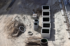 Neatly folded rectangular reinforced concrete elements for laying water pipes in the city. Construction site of cold and hot water pipelines.