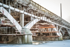 the old bridge across the river on supports, with hanging under it scaffold, during repairs