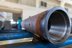Close-up view of different types of drill pipes used in the oil exploration industry, ready to use in the closed storage area
