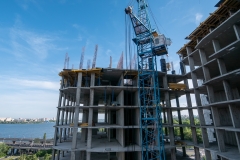 Construction site of new multi-storey residential building, industrial construction crane and other industry equipment