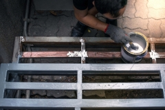 Hand of worker in a cotton glove painting steel, hand of man painting steels with gray primer.